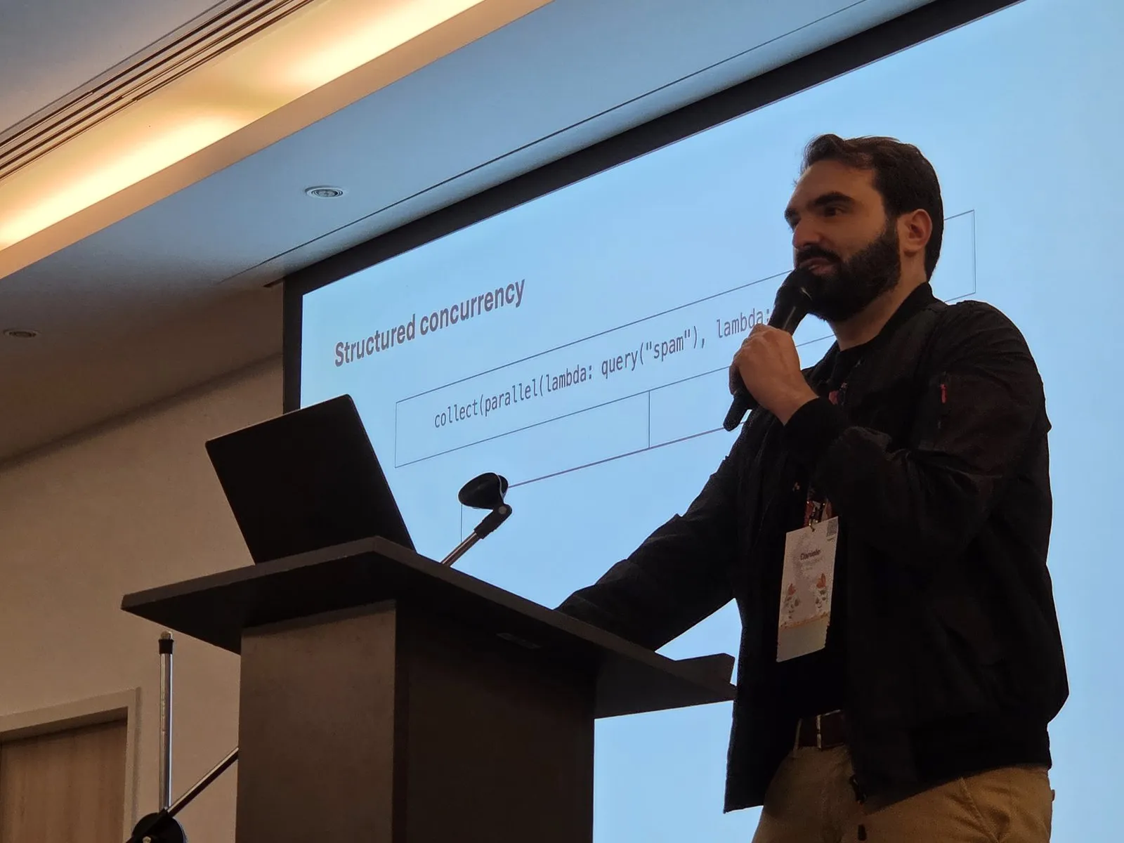 Daniele Parmeggiani at the lectern, in front of his “Structured concurrency” slide