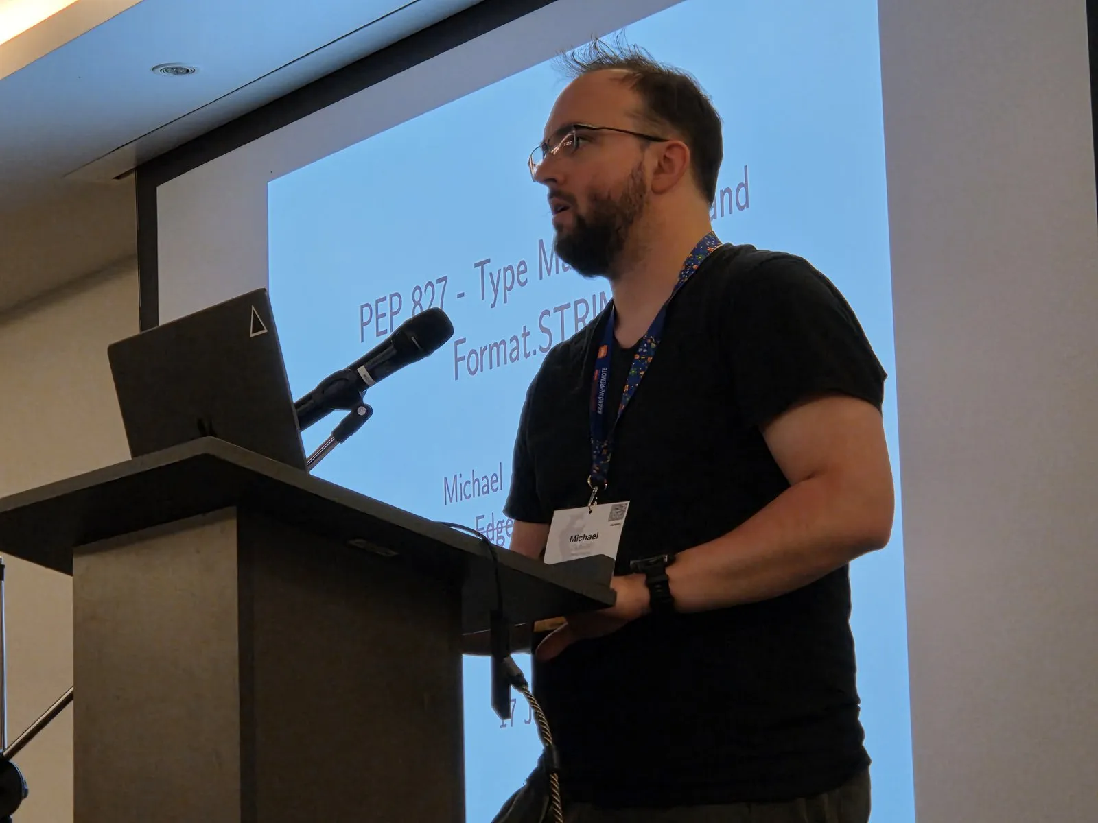 Michael J. Sullivan at the lectern, in front of his PEP 827 title slide