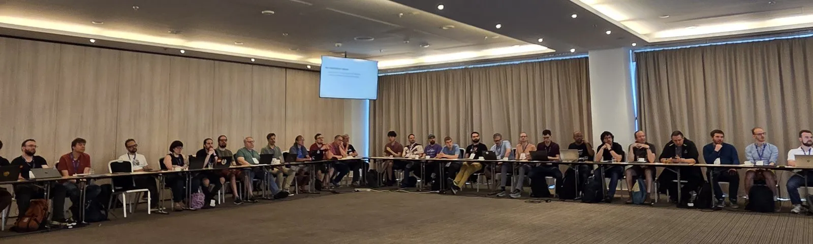 Language Summit attendees seated along the U-shaped table